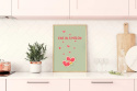 Aranżacja kuchni. Na blacie w kuchni stoi plakat przedstawia dwa serduszka  z małymi serduszkami nad nim oraz napisem One in a melon.